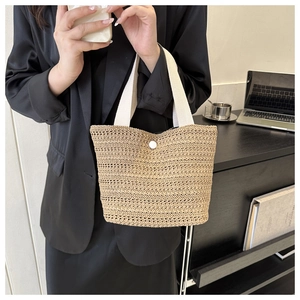 Détail d'un grand sac cabas tissé avec poignées en toile blanche et fermeture à bouton