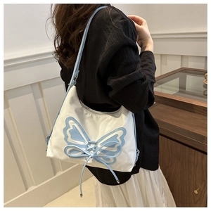 Détail du sac bandoulière blanc avec patchwork papillon bleu et laçage croisé