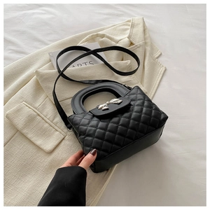 Vue détaillée du sac en similicuir matelassé noir avec un nœud métallique argenté chic