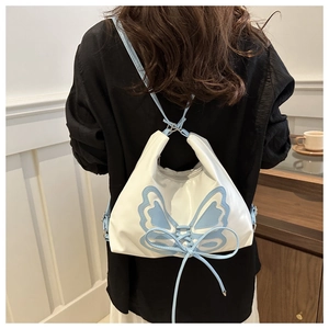 Detail view of the white leather backpack with blue butterfly design and lacing straps
