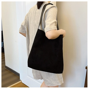 Dettaglio della grande borsa tote in pelle scamosciata nera opaca con tracolla larga
