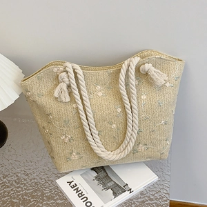 Straw tote bag with floral embroidery and white rope handles for summer beach use
