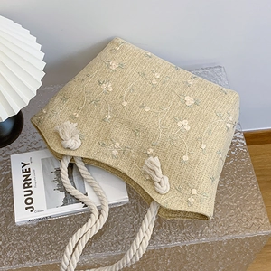 Beige straw tote bag with floral embroidery and thick cotton rope handles for summer