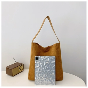 Dettaglio della grande borsa tote in pelle scamosciata marrone con radio vintage