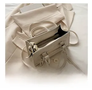 Vue de dessus d'un sac à main crème montrant les compartiments et la poche zippée