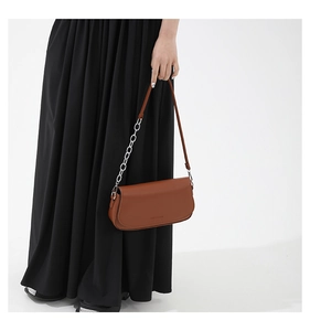 Detail of brown saddle bag showing fine stitching and silver chain strap for women