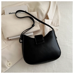 Detail view of black PU leather shoulder bag with adjustable silver buckle strap