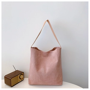Dettaglio della borsa tote in pelle scamosciata rosa con tracolla in pelle marrone ed elegante