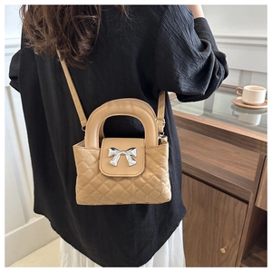 Détail du sac à main matelassé beige avec boucle nœud argenté et anse chic