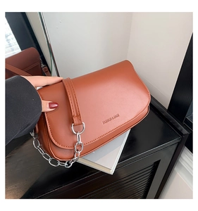 Detail of caramel brown saddle bag with Fashion & Bags embossing and silver chain