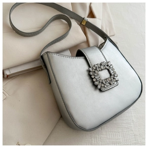 Close-up of a silver baguette bag featuring a luxury square rhinestone buckle on faux leather