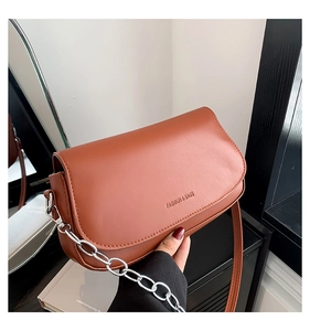 Detail of reddish-brown saddle bag with silver chain and Fashion & Bags embossed text