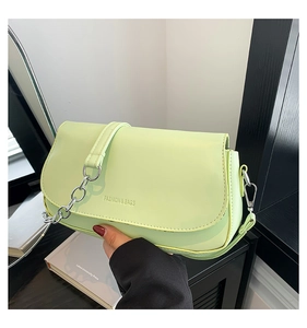 Close-up of green PU leather saddle bag with silver chain and Fashion & Bags embossing