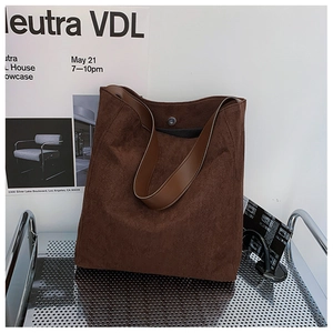 Dettaglio della borsa tote marrone scuro con chiusura magnetica e texture scamosciata