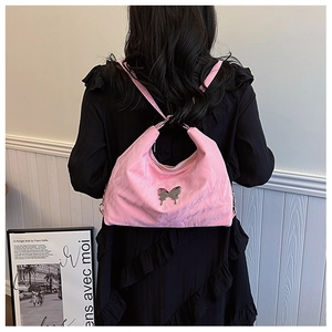 Detail view of pink butterfly shoulder bag with pleated texture on black dress