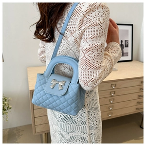 Détail du sac à main matelassé bleu clair avec boucle nœud argenté et dentelle élégante