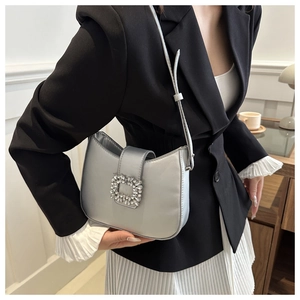 Gros plan sur le sac baguette en satin argenté avec boucle carrée en cristal de luxe