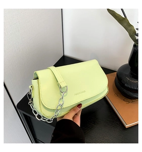 Detail of mint green PU leather saddle bag with silver chain strap and fashion text