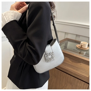Détail du sac à bandoulière argenté métallisé avec une boucle carrée ornée de cristaux