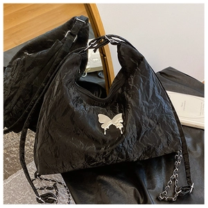 Detail of black pleated hobo bag featuring a silver liquid butterfly metal buckle detail
