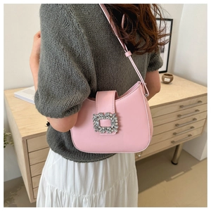 Detailed view of a pink baguette shoulder bag with a sparkling crystal square buckle