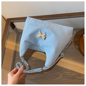Close-up of light blue pleated shoulder bag with silver butterfly metal ornament and zipper