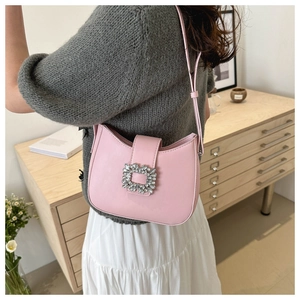 Detail of pink PU leather baguette bag with a square crystal buckle on the shoulder strap
