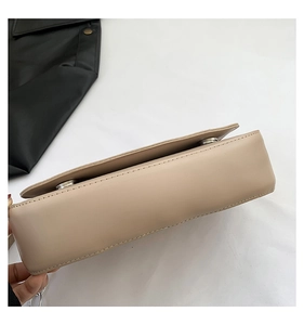 Detail view showing the side thickness and smooth beige leather texture of the saddle bag