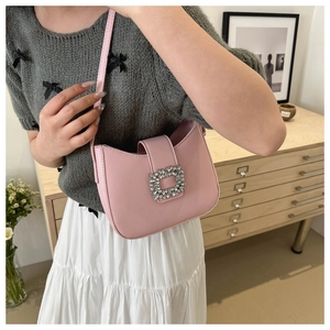 Detail of pink leather underarm bag featuring a crystal square buckle and smooth finish