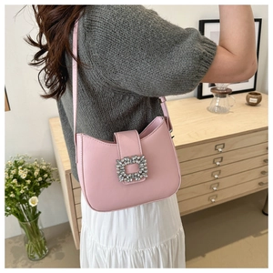 Detailed side view of pink baguette shoulder bag with sparkling rhinestone buckle