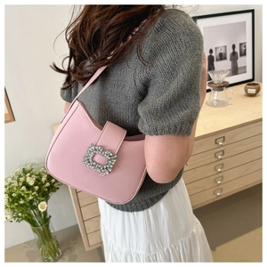 Pink hobo shoulder bag featuring a large crystal-embellished buckle on a textured finish