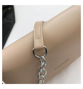Detailed close-up of beige leather saddle bag featuring silver chain and Fashion & Bags text