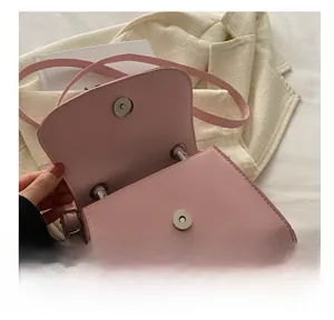 Detail view of pink PU leather handbag featuring a magnetic snap closure and metal hardware
