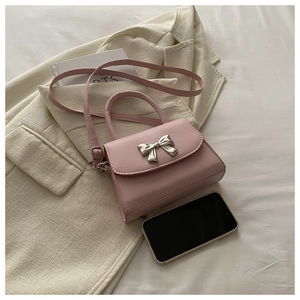 Detailed view of pink mini crossbody bag with a decorative silver metal bow clasp