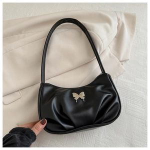 Detail of silver butterfly buckle on black pleated crescent moon shoulder bag
