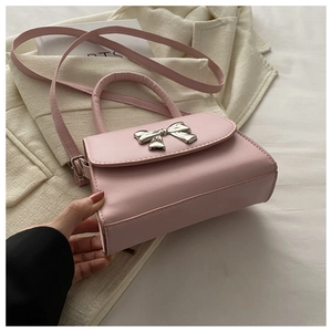 Dettaglio mini borsa quadrata rosa con fiocco in metallo argento e manico tondo