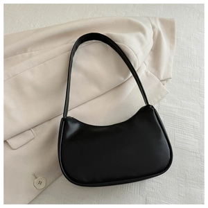 Detailed top view of black crescent shoulder bag on a beige blazer with minimalist vibe
