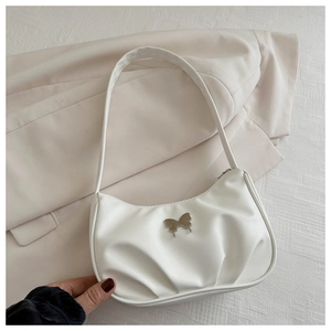 Detail of white pleated PU leather crescent bag with silver butterfly charm decoration