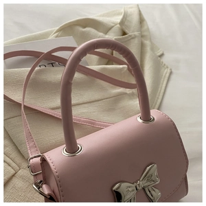 Dettaglio mini borsa a tracolla rosa con fiocco metallico argento e manico superiore