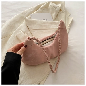 Pink crescent underarm bag with pleated texture and braided strap showing phone storage