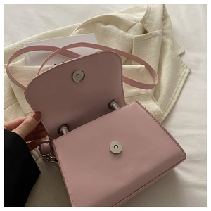 Dettaglio borsa a tracolla in pelle rosa con chiusura magnetica in metallo argento