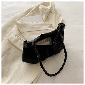 Detail of a black pleated underarm bag featuring a trendy woven twisted shoulder strap