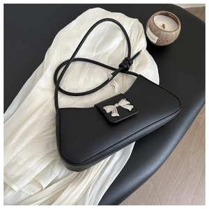 Close-up of black PU leather shoulder bag featuring silver metal bow and knotted strap