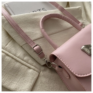 Dettaglio della mini borsa quadrata in pelle rosa con fibbia metallica a coda di balena