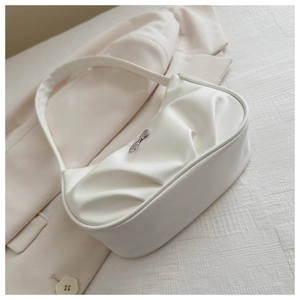 Detailed view of the pleated texture and silver logo on a white crescent shoulder bag