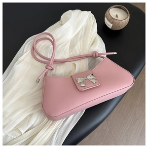 Close-up of pink faux leather baguette bag featuring a silver metal bow buckle detail