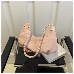 Detail of light pink ruched hobo bag with braided handle and unique pleated texture