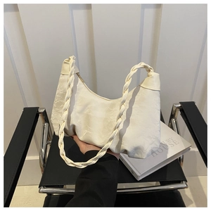 Detail of off-white pleated crescent bag featuring a stylish twisted woven shoulder strap