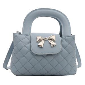 Sac à main matelassé bleu clair avec boucle nœud argentée et bandoulière en vue latérale