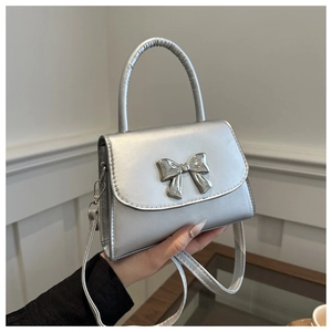 Dettaglio della mini borsa quadrata argento con fibbia a fiocco e tracolla regolabile